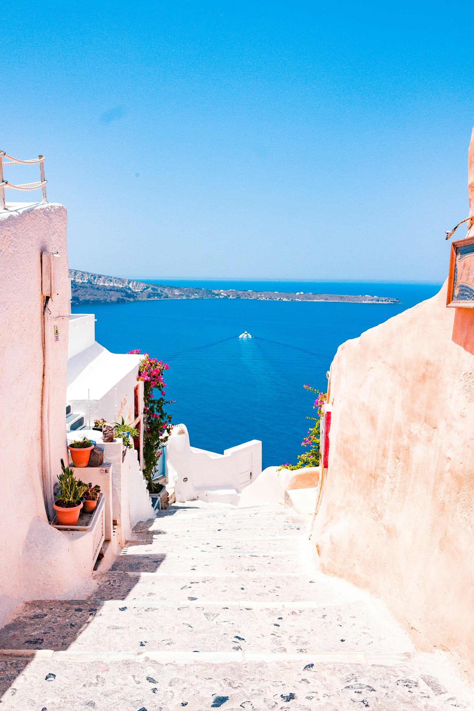 Whitewashed village steps descending toward a deep blue sea