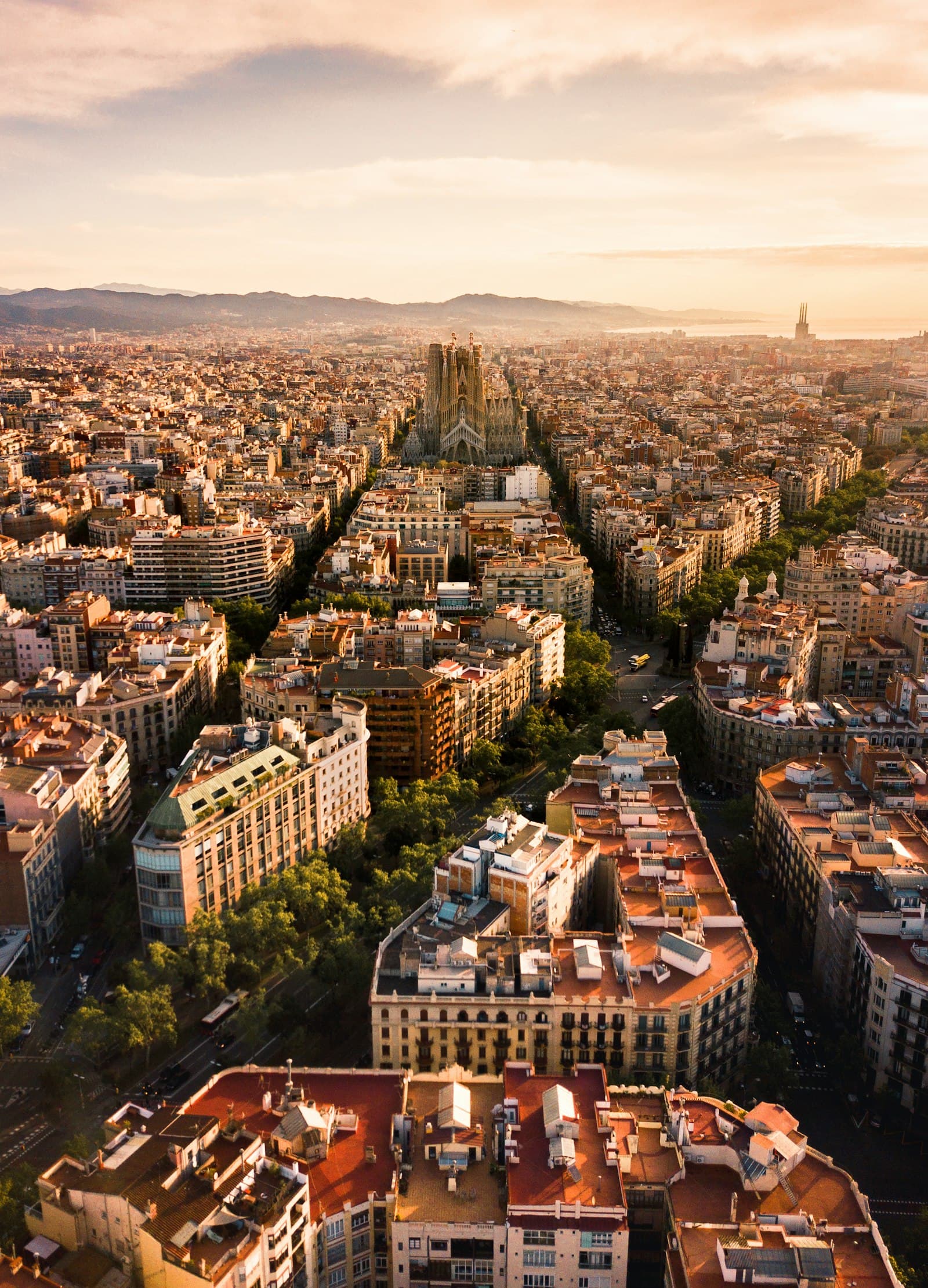 Barcelona's Eixample glowing at sunrise, the sea beyond