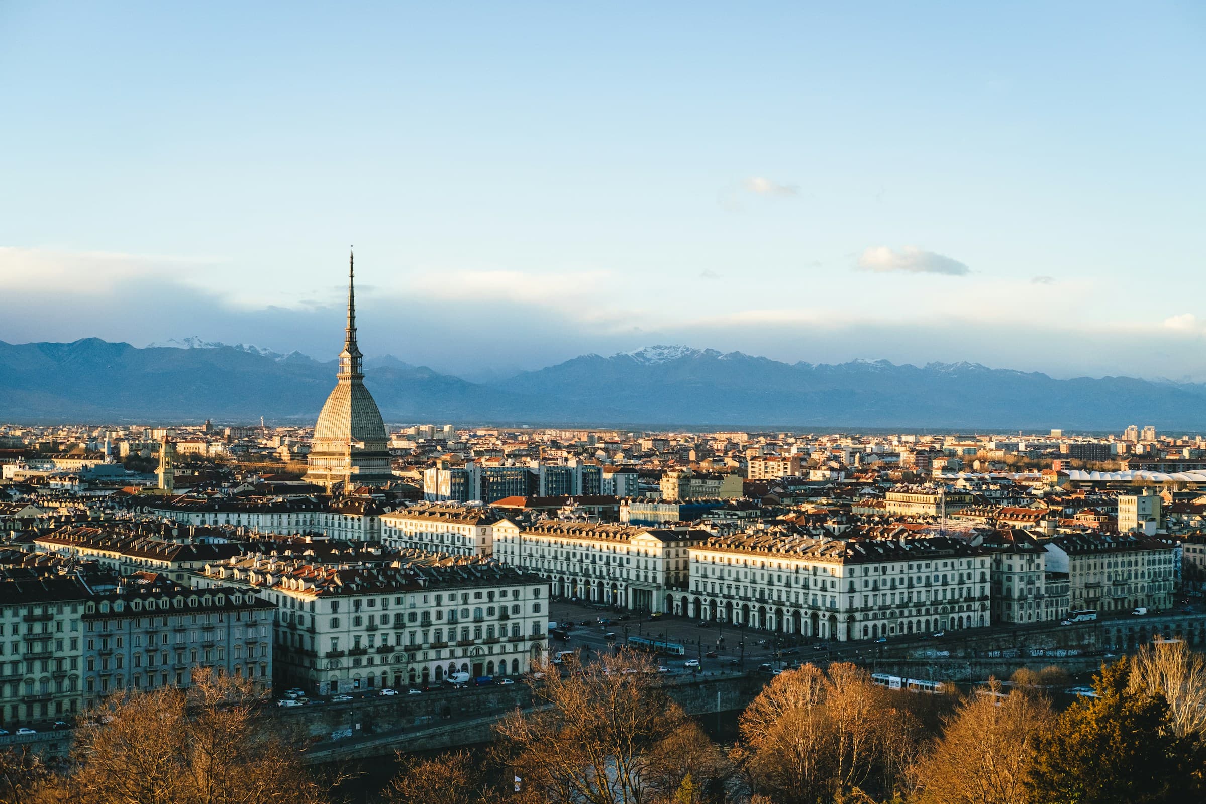Turin from above: terracotta rooftops, the grid of the centre and the Mole rising over the city