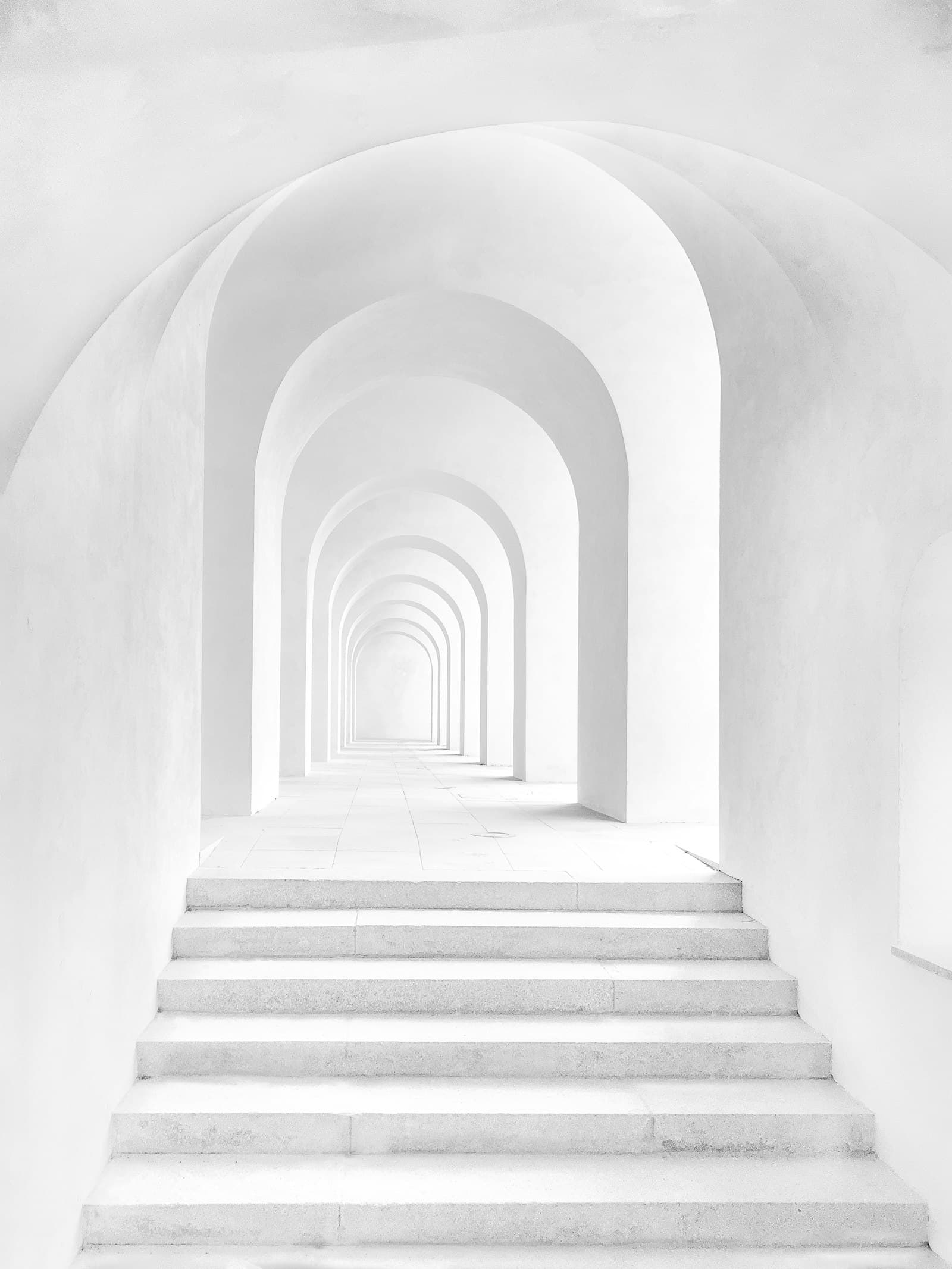 Sunlit corridor of whitewashed arches